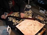 砥石を使って三味線の棹の表面を整える作業